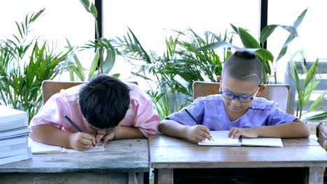 Asian-boy-two-people-with-writing-homework.-education-concept