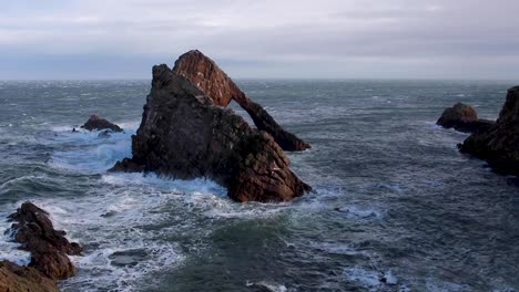 grobe-stürmischen-Wellen-gegen-ein-Meer-Felsen-Stack-in-Schottland-während-einer-stürmischen-Herbstnachmittag.