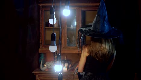 Bruja-de-Halloween-en-un-sombrero-tiene-una-vela-en-sus-manos.