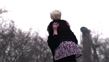 A-girl-runs-and-jumps-into-her-boyfriend's-arms-in-a-park-on-a-cloudy-day