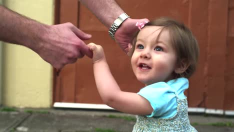 Una-niña-camina-por-la-calle-con-la-ayuda-de-un-adulto