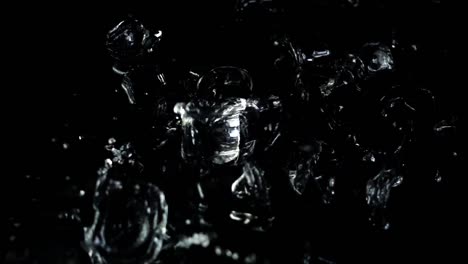 Falling-of-cubes-of-ice-on-a-black-background.-Slow-motion.