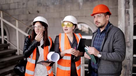 The-engineer-communicates-with-the-female-customer-representatives-at-the-construction-site,-checking-the-drawings-with-the-actual-progress-of-construction-work