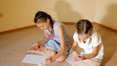 girls-drawing-with-watercolors-on-paper-and-on-hands