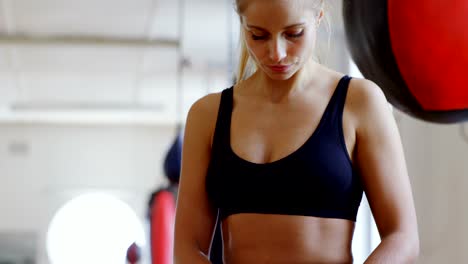 Female-boxer-using-mobile-phone-in-fitness-studio-4k