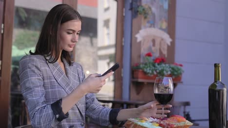 Beautiful-Woman-Taking-Food-Photos-On-Mobile-Phone-At-Restaurant