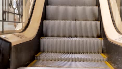 Escalator-in-the-mall-close-up.-In-the-background,-people-are-out-of-focus-for-shopping.