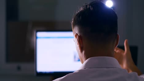 Back-view-Man-browsing-Internet-Sites-on-Computer-Monitor.-Web-Pages-Surfing,-Concept-of-searching-for-information-on-the-Internet.