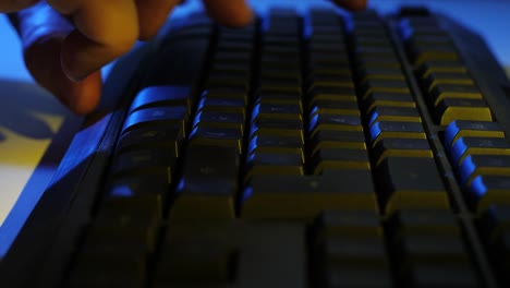 Typing-On-Black-Keyboard-Colored-Light-Close-Up-Traveling