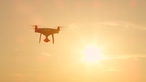 SILUETA-lenta:-Abejón-de-Quadcopter-volando-hacia-la-cámara-al-atardecer-dorado