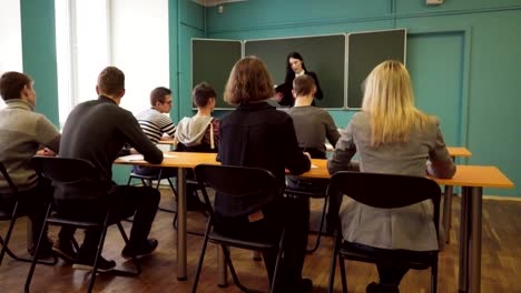 Profesor-de-la-mujer-habla-a-los-estudiantes-en-el-aula