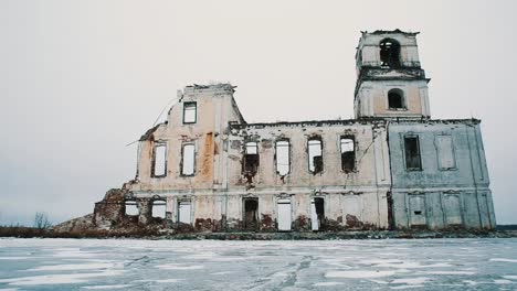 Ruined-chapel-building-in-middle-of-frozen-lake-covered-in-snow