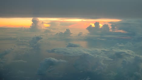 Vista-aérea-de-nubes-blancas-sobre-cielo-azul-en-la-salida-del-sol-con-el-reflejo-en-el-océano