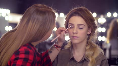 The-makeup-artist-correcting-the-shape-of-eyebrow