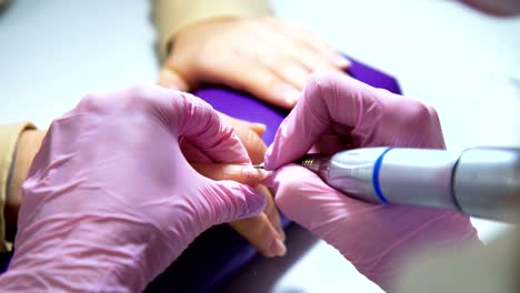 Beautician-careful-and-accurate-removing-cuticles-with-polish-machine