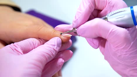 Beautician-careful-and-accurate-removing-cuticles-with-polish-machine