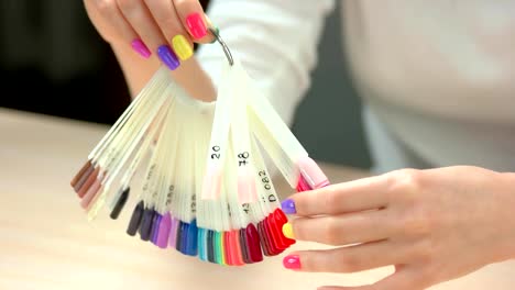 Well-groomed-hands-holding-nail-samples.