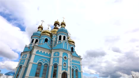 Orthodox-temple,-Clouds-above-the-temple,-golden-domes,-Timelapse,-exterior,-a-view-from-below,-Blue-temple,-blue-church,-Against-the-sky,-Golden-domes