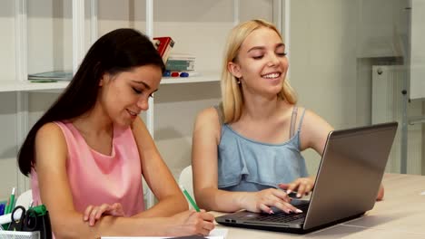 Zwei-schöne-weibliche-Studierende-mit-Laptop-zusammen