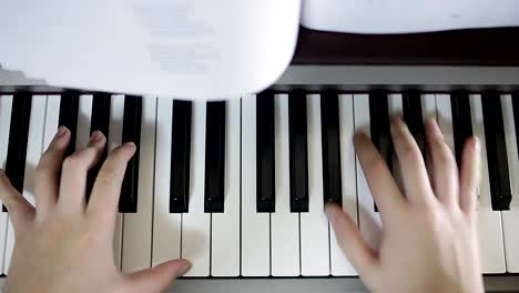 Teen-girl-plays-on-the-keyboard-of-the-digital-piano.-Close-up