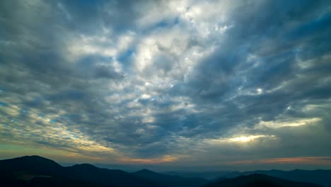 The-beautiful-cloud-stream-with-a-sunset-above-mountains.-time-lapse