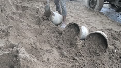 Mit-einer-Schaufel-Sand-in-einen-Eimer-zu-setzen-(Nahaufnahme)