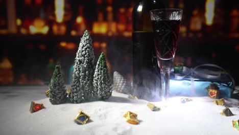 Glas-Wein-mit-Weihnachtsdekoration.-Rotwein-in-Kristall-Glas-auf-Schnee-mit-kreativen-Neujahr-Kunstwerk.-Textfreiraum