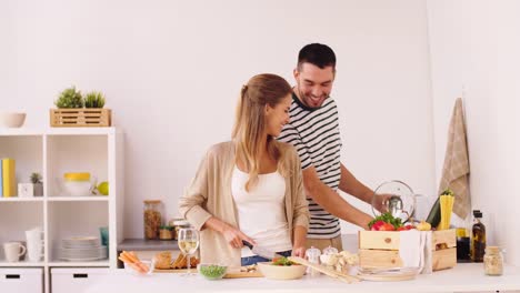 glückliches-Paar-Garen-von-Speisen-in-der-Küche-zu-Hause