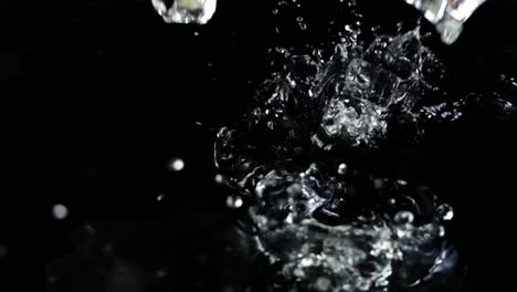 Falling-of-cubes-of-ice-on-a-black-background.-Slow-motion.