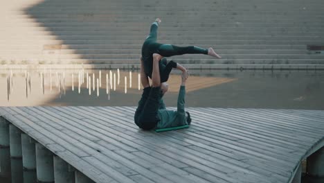 Beautiful-couple-practicing-acro-yoga-in-the-morning