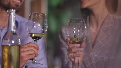 Couple-Cheering-With-White-Wine-Glasses-On-Romantic-Dinner