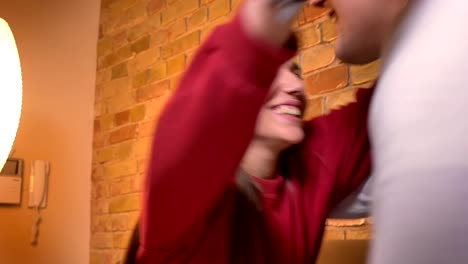 Close-up-portrait-of-girl-with-eyes-closed-getting-present-and-becoming-happy-embracing-her-friend-in-home-atmosphere.