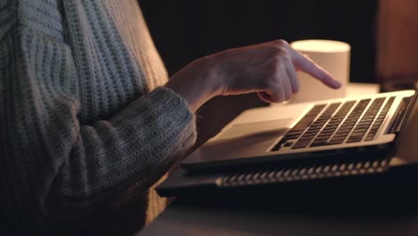 Hands-of-woman-working-on-laptop-in-dark-room.-Close-up