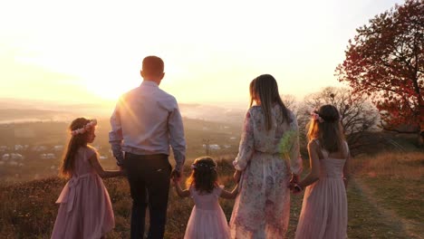 Familie-zu-Fuß-und-beobachten-den-Sonnenuntergang