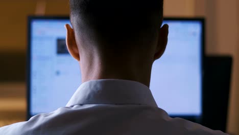 Back-view-Man-browsing-Internet-Sites-on-Computer-Monitor.-Web-Pages-Surfing,-Concept-of-searching-for-information-on-the-Internet.