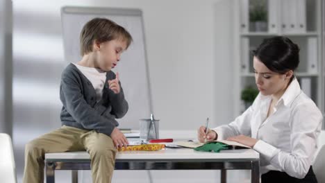 Mutter-arbeitet-im-Büro-mit-kleinem-Sohn