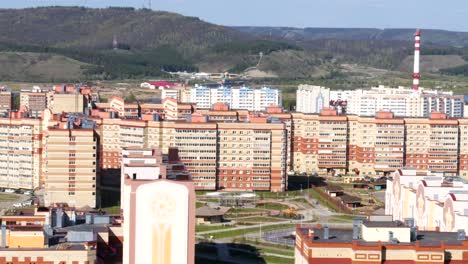 Vuelo-por-encima-del-distrito-con-edificios-y-terreno-deportivo