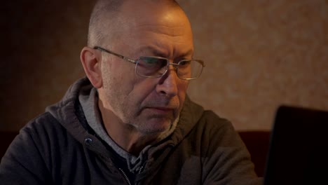 old-man-using-laptop-computer-at-home