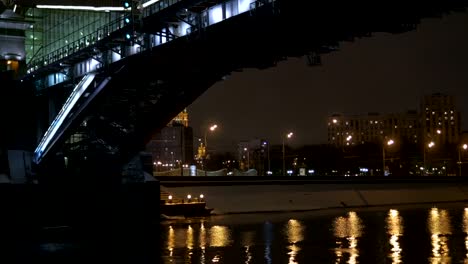 Vista-desde-la-cubierta-de-la-nave,-que-flota-en-el-río,-a-lo-largo-de-la-decoración-para-la-fiesta.-Nada-debajo-de-un-puente-hermoso.