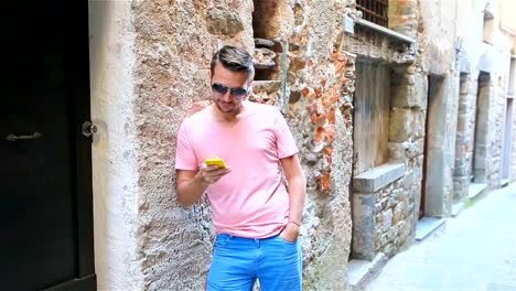 Urban-caucasian-boy-walking-in-street-at-Europe.-Young-man-with-phone-outdoors