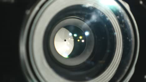 Video-camera-lens,-showing-zoom-and-glare,-turns,-close-up