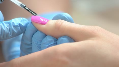 Slow-motion-manicurist-polished-nail-to-client.