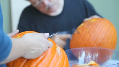 Two-men-carving-Halloween-pumpkins