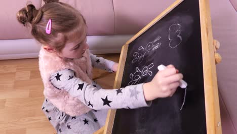 Little-girl-is-drawing-on-a-blackboard