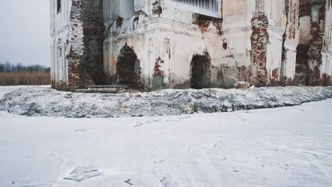 Ruined-cathedral-building-in-middle-of-frozen-lake-covered-in-snow