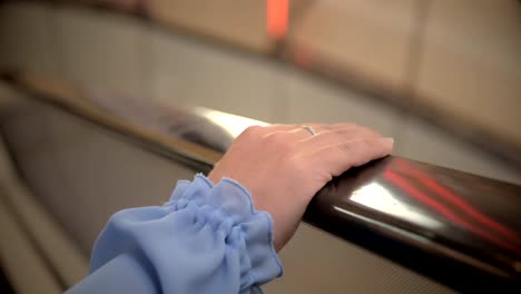 Female-hand-on-escalator-or-moving-staircase-rails