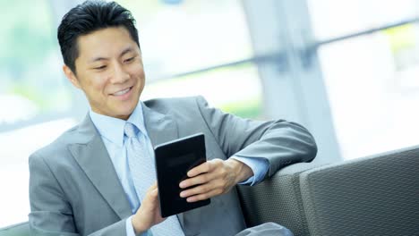 Asian-Chinese-businessman-using-touch-screen-mini-tablet