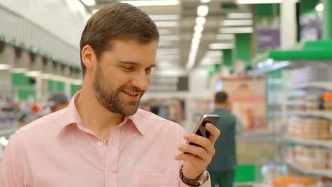 Male-customer-using-mobile-phone-in-shopping-mall