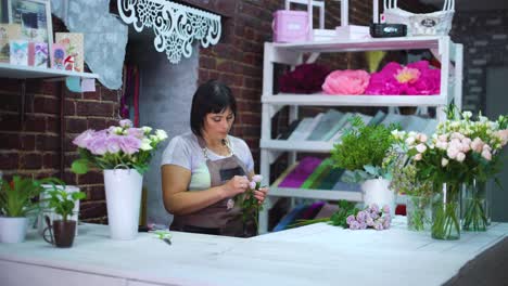 Professional-florist-clearing-and-inspecting-white-rose-branch-from-dry-petals