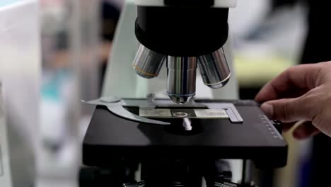 Médico-en-los-trabajos-de-laboratorio-con-un-microscopio